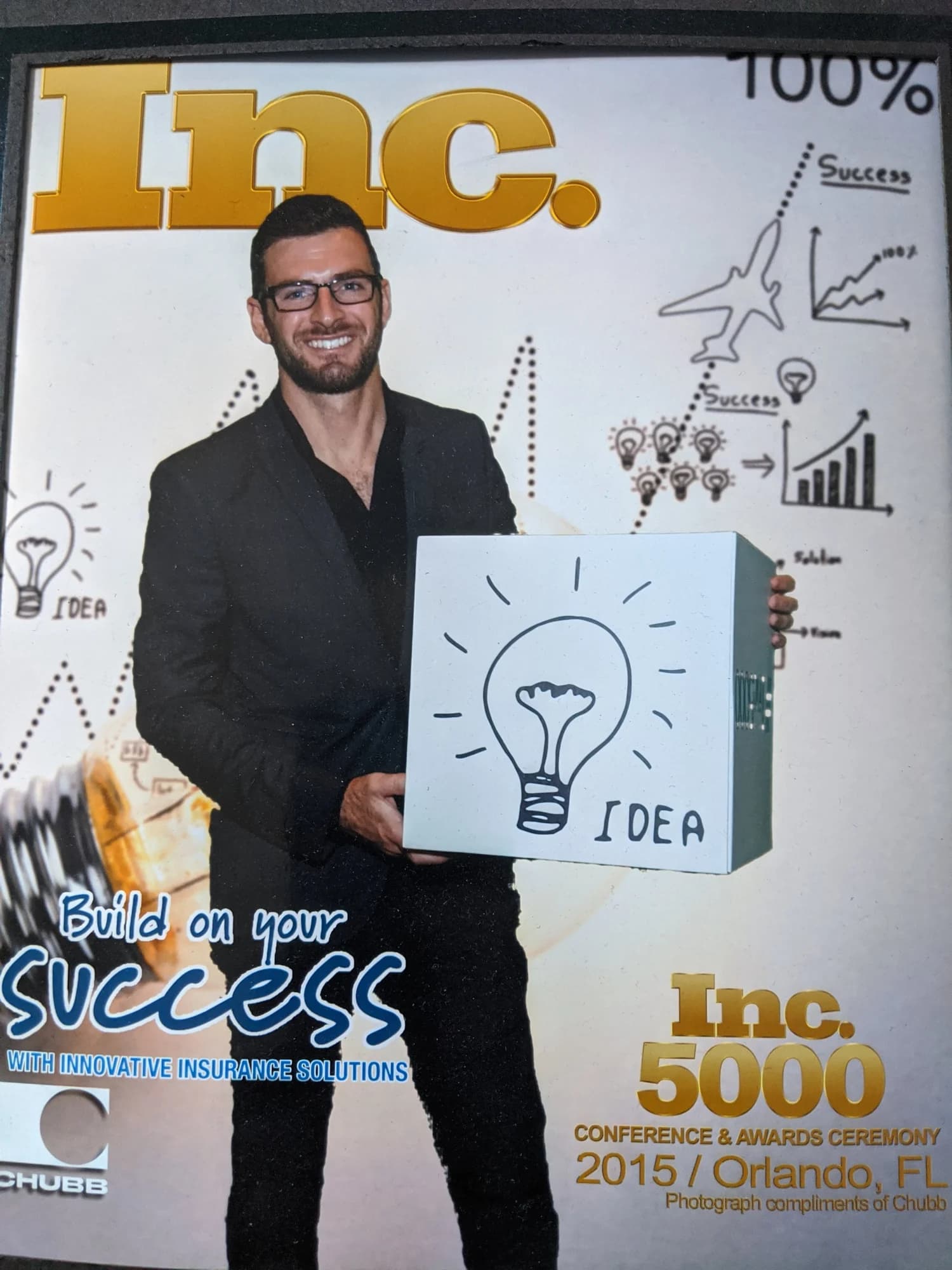 Grant Kendzior holding an “idea” light-bulb sign at the Inc. 5000 Conference & Awards Ceremony